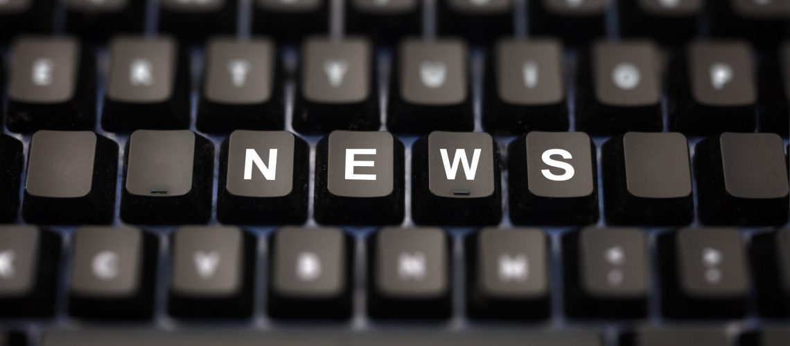 Online news, journalism concept. News word written on keypad. Black keys with white letters message for press articles on pc keyboard. Blur buttons background.